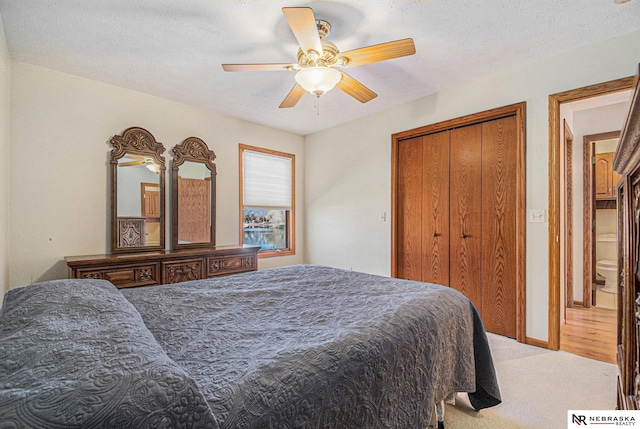 carpeted bedroom featuring a textured ceiling, a closet, baseboards, and a ceiling fan
