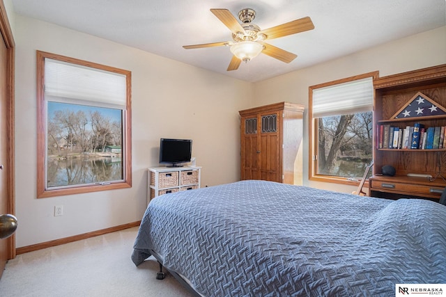 bedroom with light carpet, baseboards, and ceiling fan