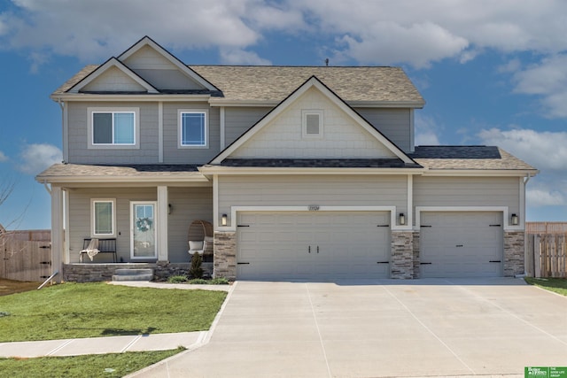 craftsman-style home with roof with shingles, driveway, an attached garage, a porch, and fence