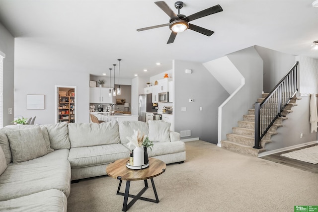 living room with a ceiling fan, recessed lighting, stairway, light carpet, and baseboards