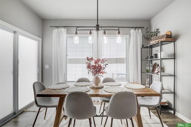 dining space with light wood-style flooring, baseboards, and a wealth of natural light