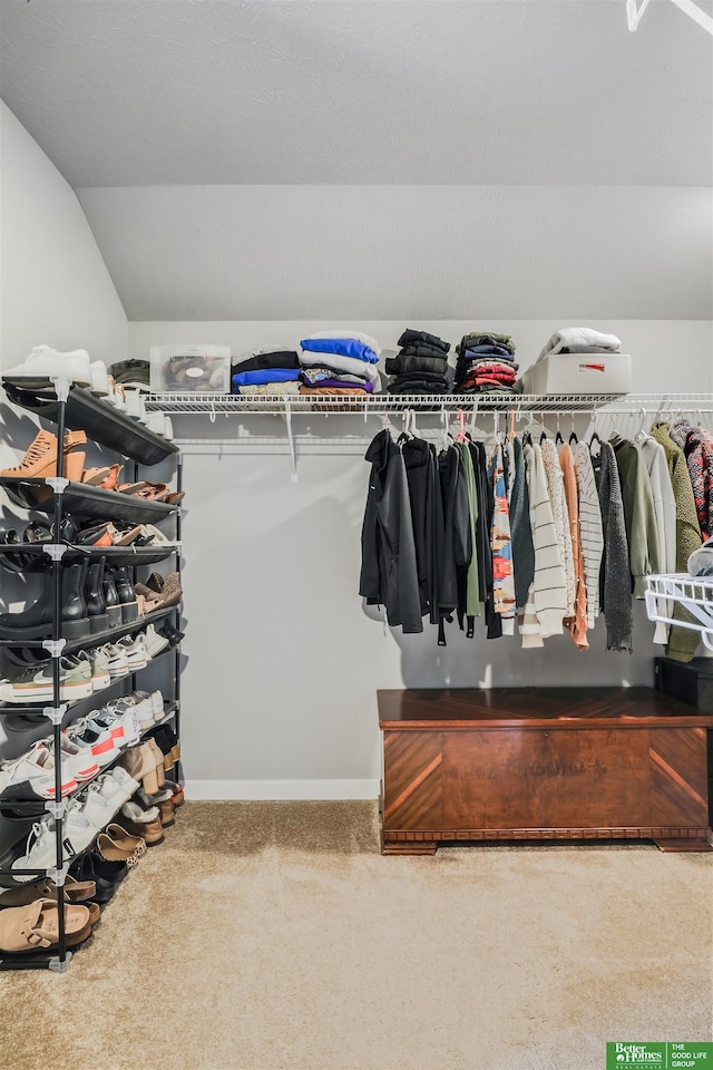 spacious closet with vaulted ceiling and carpet floors