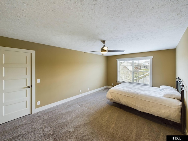 carpeted bedroom featuring a textured ceiling, baseboards, and a ceiling fan