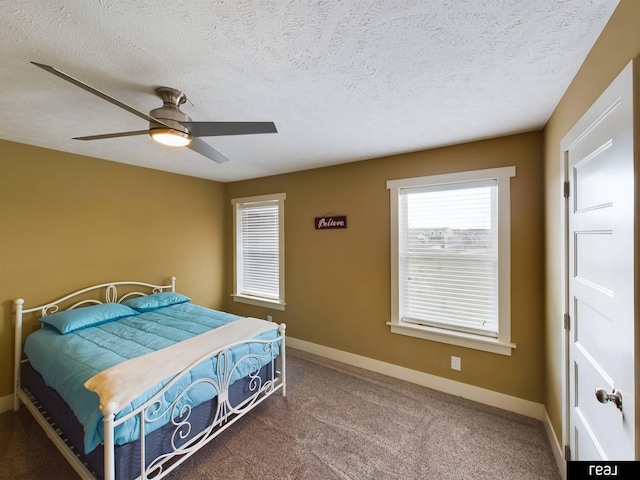 carpeted bedroom featuring baseboards, a textured ceiling, and ceiling fan