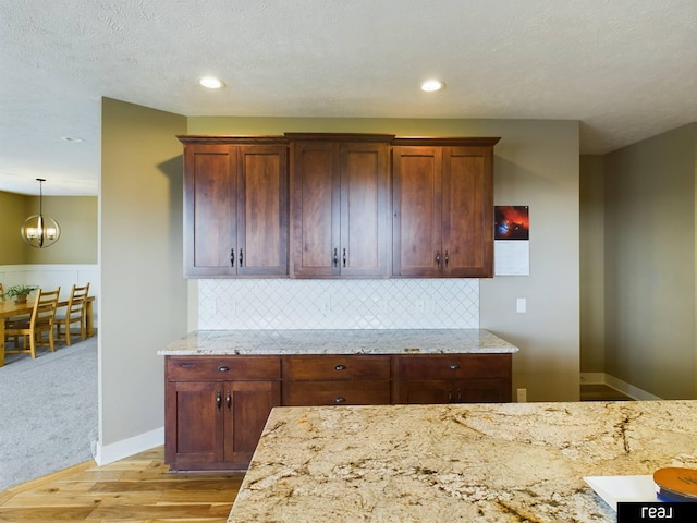 kitchen with decorative backsplash, light wood finished floors, recessed lighting, and light stone countertops