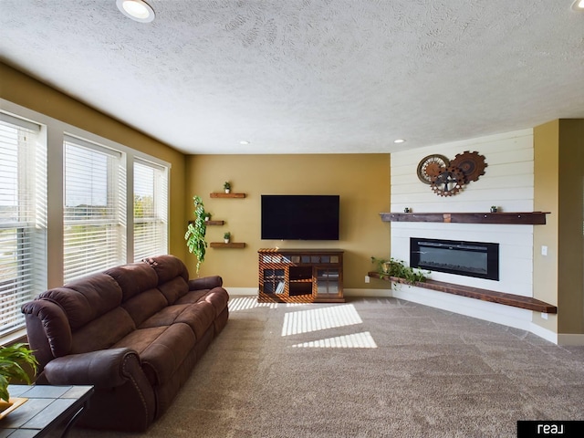 living room with recessed lighting, baseboards, a glass covered fireplace, and carpet floors
