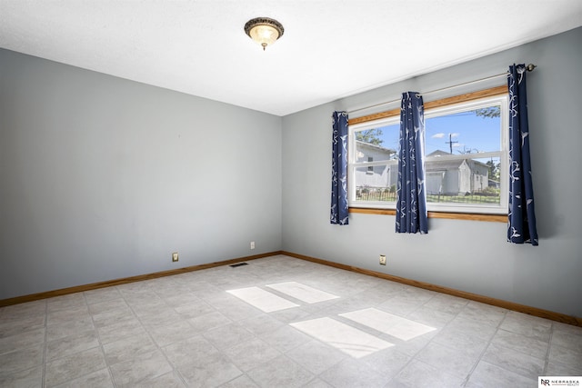 spare room with baseboards
