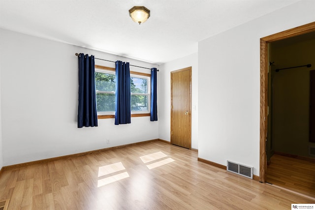 unfurnished bedroom featuring light wood-type flooring, baseboards, and a closet