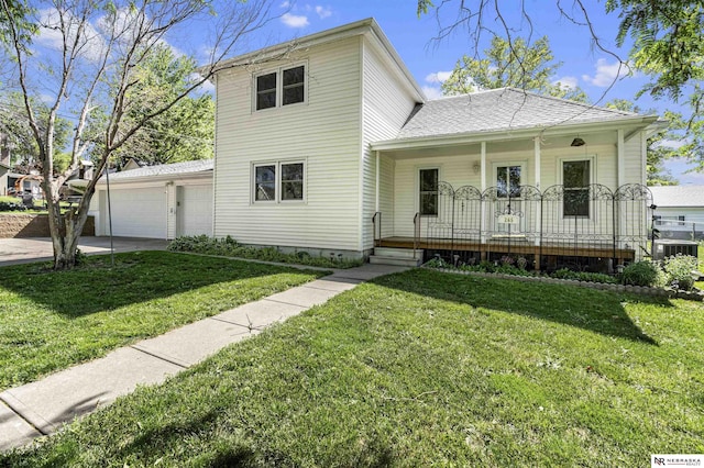 traditional home with a porch, an attached garage, concrete driveway, a front lawn, and central AC unit