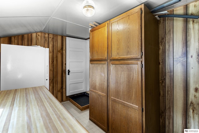 additional living space with vaulted ceiling and wood walls