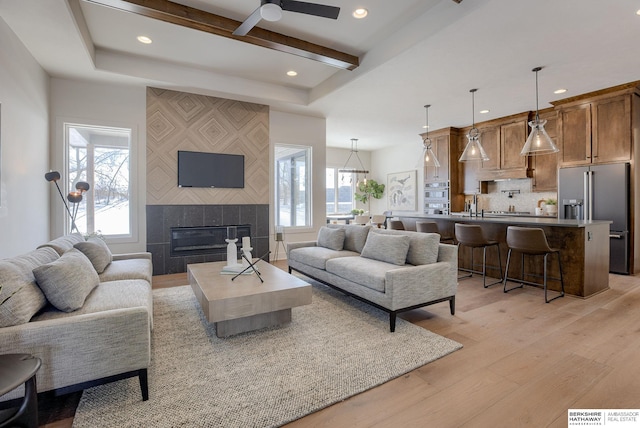 6511 Garvin St, Omaha, NE 68152 - living room featuring light wood-type flooring, a fireplace, a ceiling fan, and beamed ceiling