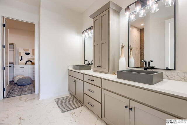 6511 Garvin St, Omaha, NE 68152 - bathroom with baseboards, marble finish floor, double vanity, and a sink