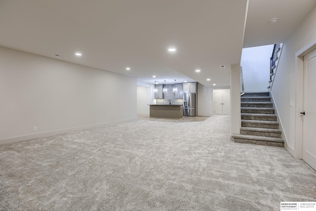 6511 Garvin St, Omaha, NE 68152 - basement featuring stainless steel fridge with ice dispenser, stairway, baseboards, light carpet, and recessed lighting