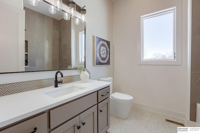 6511 Garvin St, Omaha, NE 68152 - bathroom with toilet, baseboards, visible vents, vanity, and speckled floor
