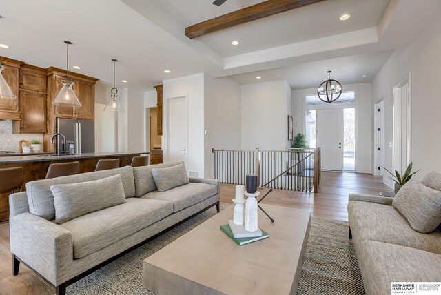 6511 Garvin St, Omaha, NE 68152 - living area featuring light wood-style flooring, beamed ceiling, a notable chandelier, and recessed lighting