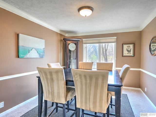 dining space with ornamental molding, carpet floors, baseboards, and a textured ceiling