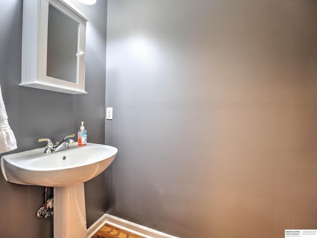 bathroom with a sink and baseboards