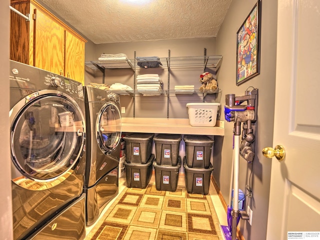 laundry area with independent washer and dryer, a textured ceiling, and cabinet space