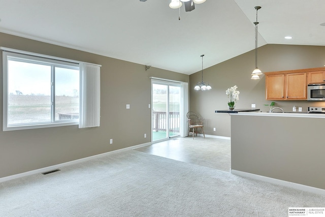 2857 Ravae Ln, Blair, NE 68008 - kitchen featuring hanging light fixtures, baseboards, stainless steel microwave, vaulted ceiling, and ceiling fan with notable chandelier