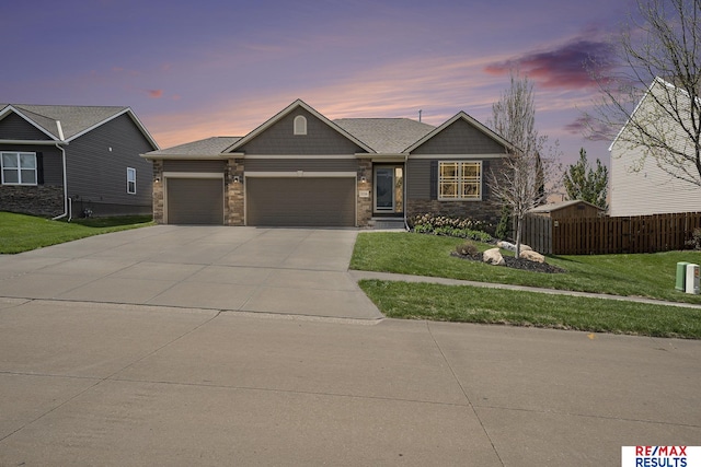 craftsman-style house with a garage, driveway, a front yard, and fence