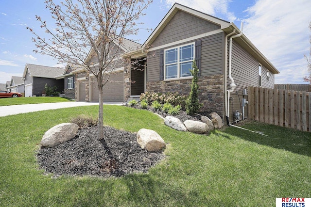 view of front facade with driveway, stone siding, fence, a garage, and a front yard