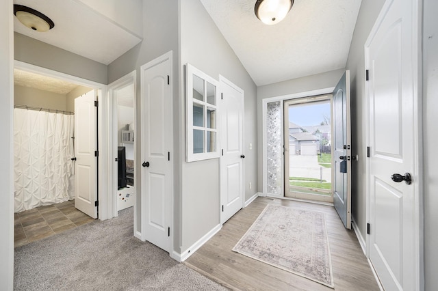 foyer entrance with a textured ceiling and baseboards