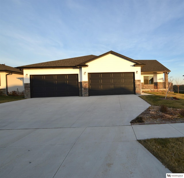 ranch-style house featuring driveway, stone siding, and a garage