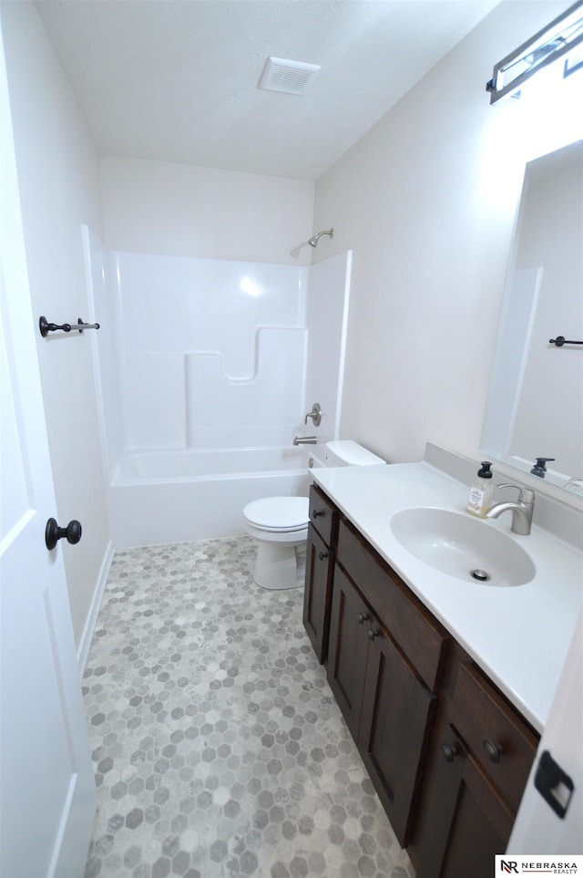 bathroom with toilet, vanity, and  shower combination