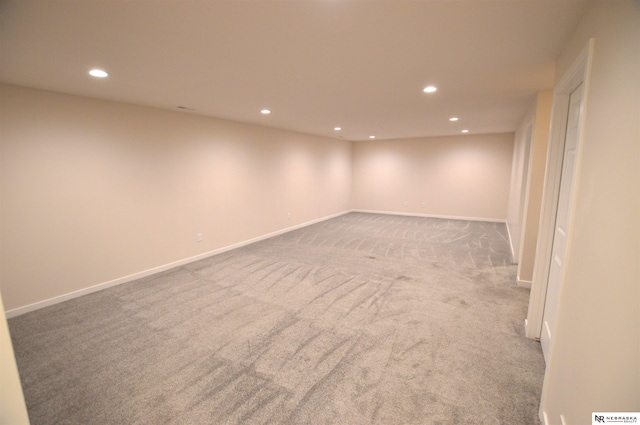 finished below grade area featuring light colored carpet, baseboards, and recessed lighting