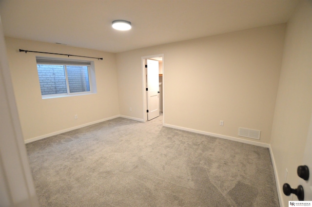 carpeted empty room featuring baseboards and visible vents