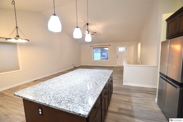 kitchen featuring a center island, freestanding refrigerator, and wood finished floors