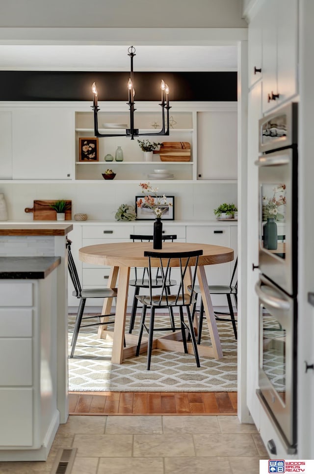 dining area featuring breakfast area, a notable chandelier, and visible vents