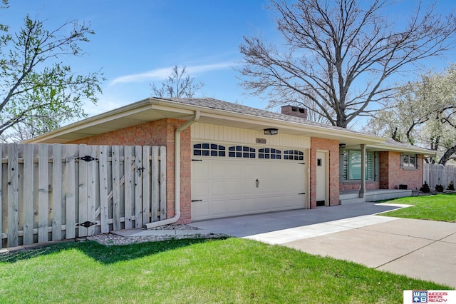 view of home's exterior with driveway, brick siding, a garage, a yard, and fence