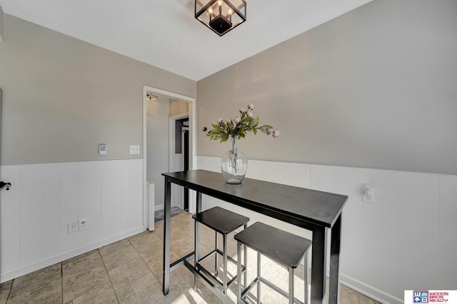 dining room featuring a decorative wall and a wainscoted wall