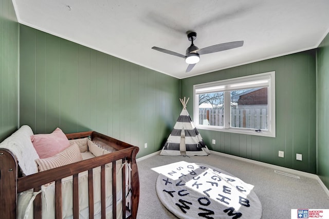 bedroom featuring crown molding, baseboards, carpet flooring, and ceiling fan