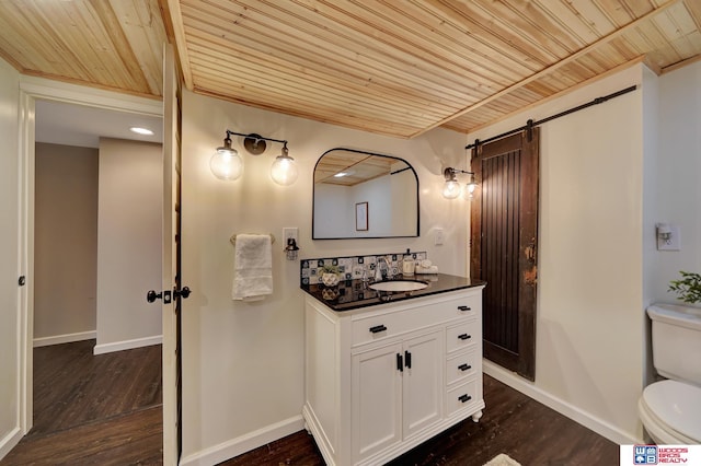 bathroom featuring baseboards, wooden ceiling, toilet, and wood finished floors