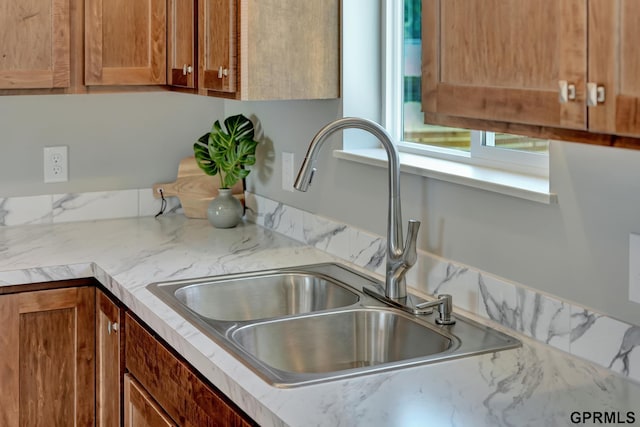 details featuring brown cabinetry and a sink