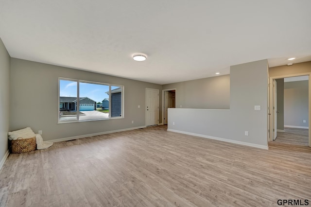 empty room with light wood-style flooring, recessed lighting, and baseboards