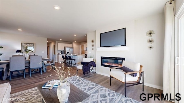 11502 Port Royal Dr, Papillion, NE 68046 - living room with baseboards, recessed lighting, a glass covered fireplace, and wood finished floors