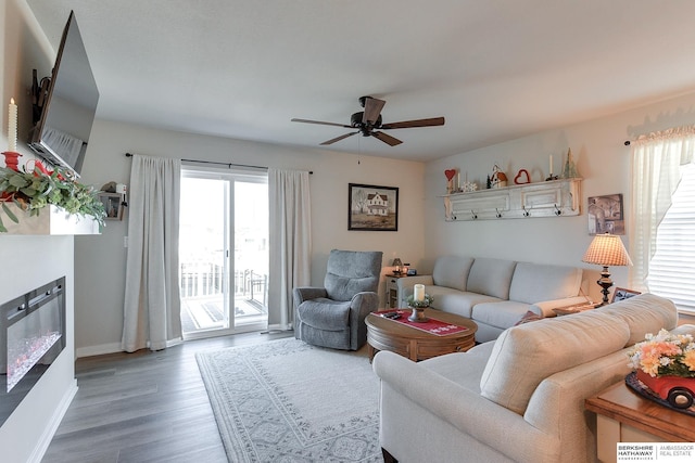 living area with ceiling fan, wood finished floors, and baseboards