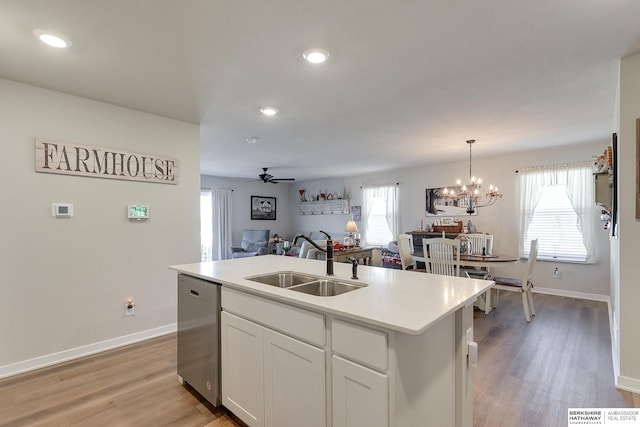 kitchen with open floor plan, dishwasher, a sink, and baseboards