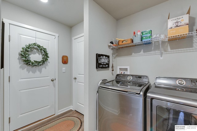 laundry area with laundry area, separate washer and dryer, wood finished floors, and baseboards
