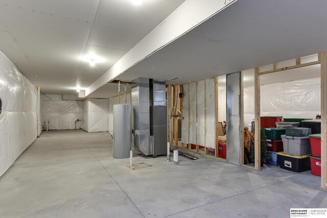 unfinished basement featuring water heater and heating unit