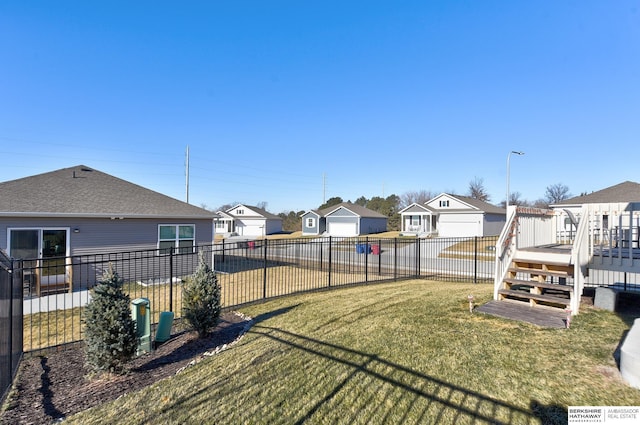view of yard featuring a fenced backyard, a deck, and a residential view