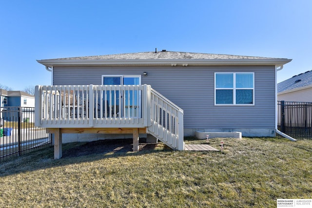 back of house featuring a yard, roof with shingles, a wooden deck, and fence