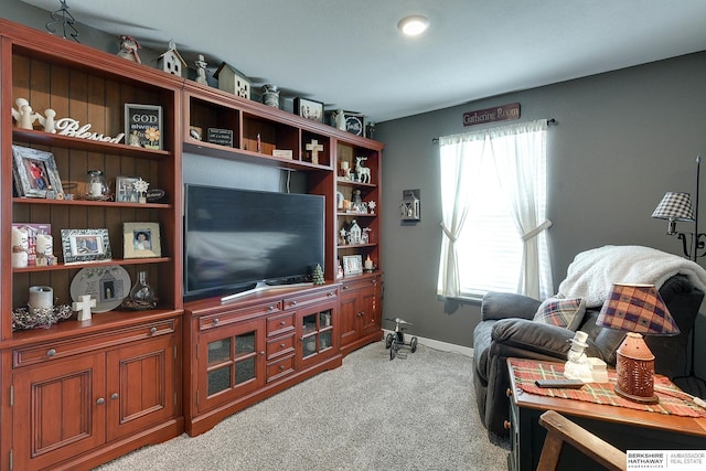 living area with light carpet and baseboards