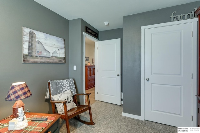sitting room featuring baseboards and carpet