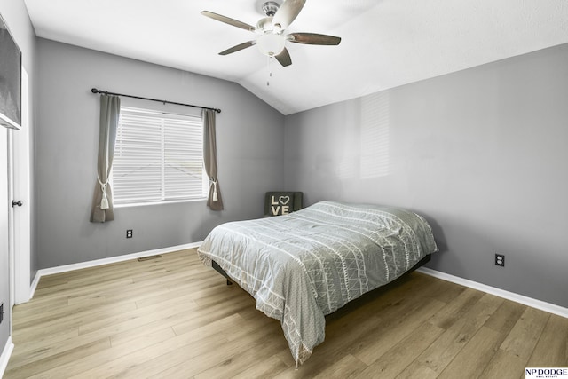 bedroom featuring wood finished floors, baseboards, lofted ceiling, and a ceiling fan