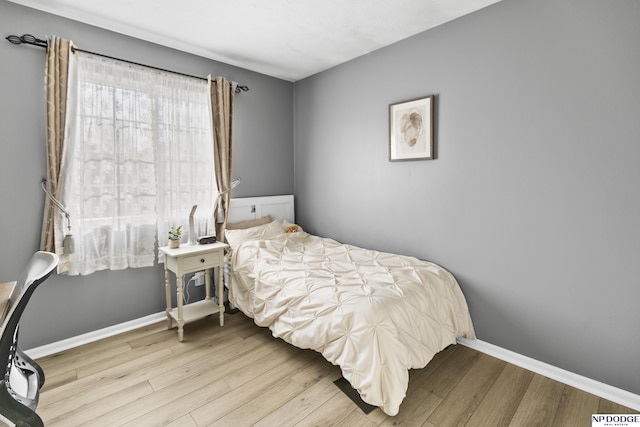 bedroom with wood finished floors and baseboards