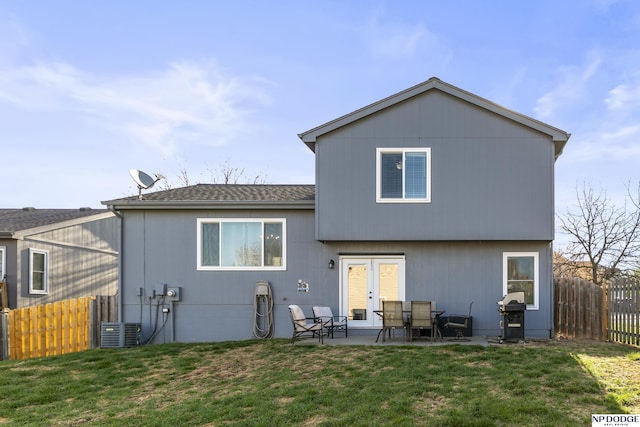 rear view of house with a patio, a shingled roof, central air condition unit, and french doors